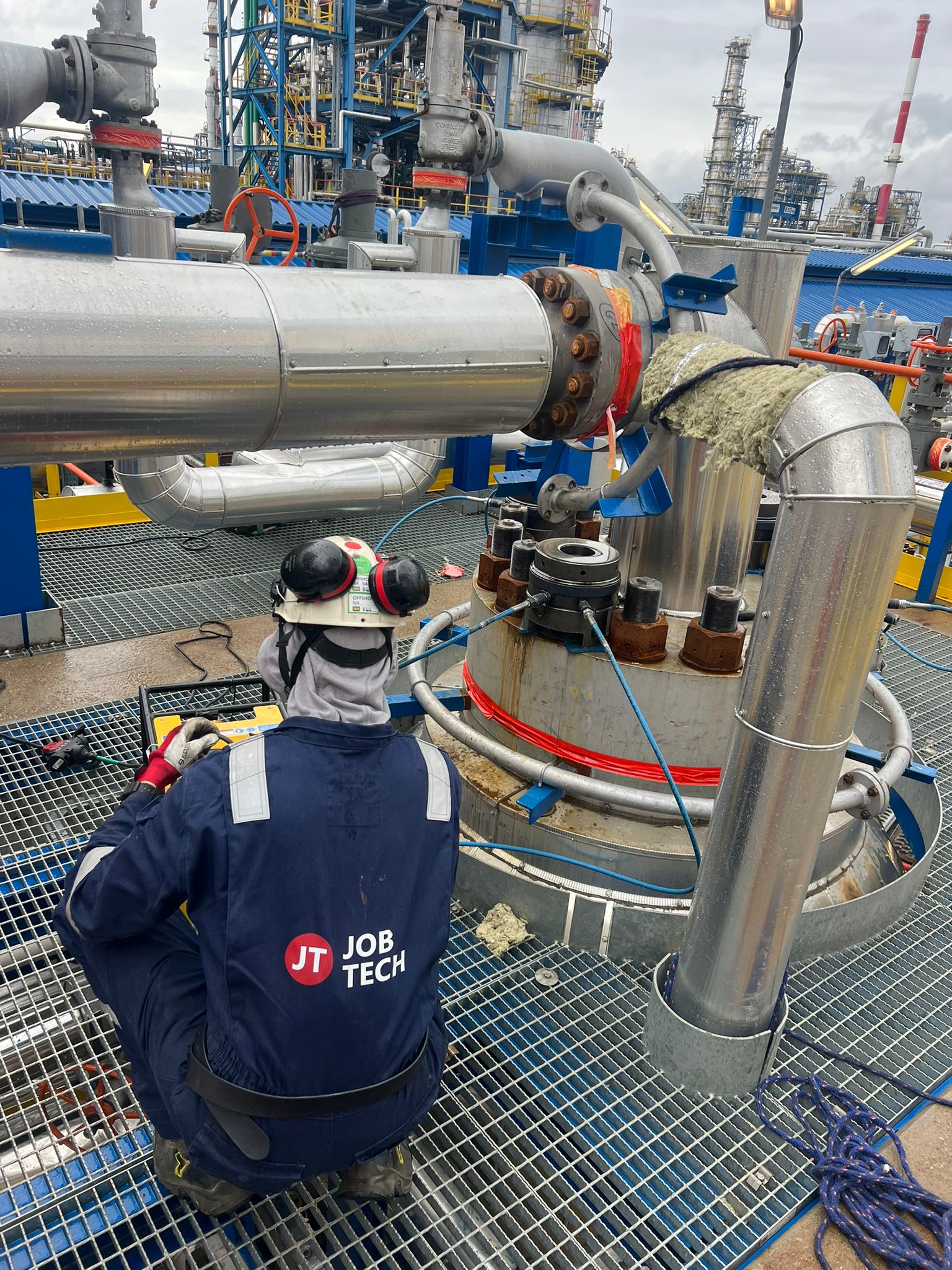 Technik JobTech wykonujący hydrauliczne napinanie śrub na instalacji przemysłowej
